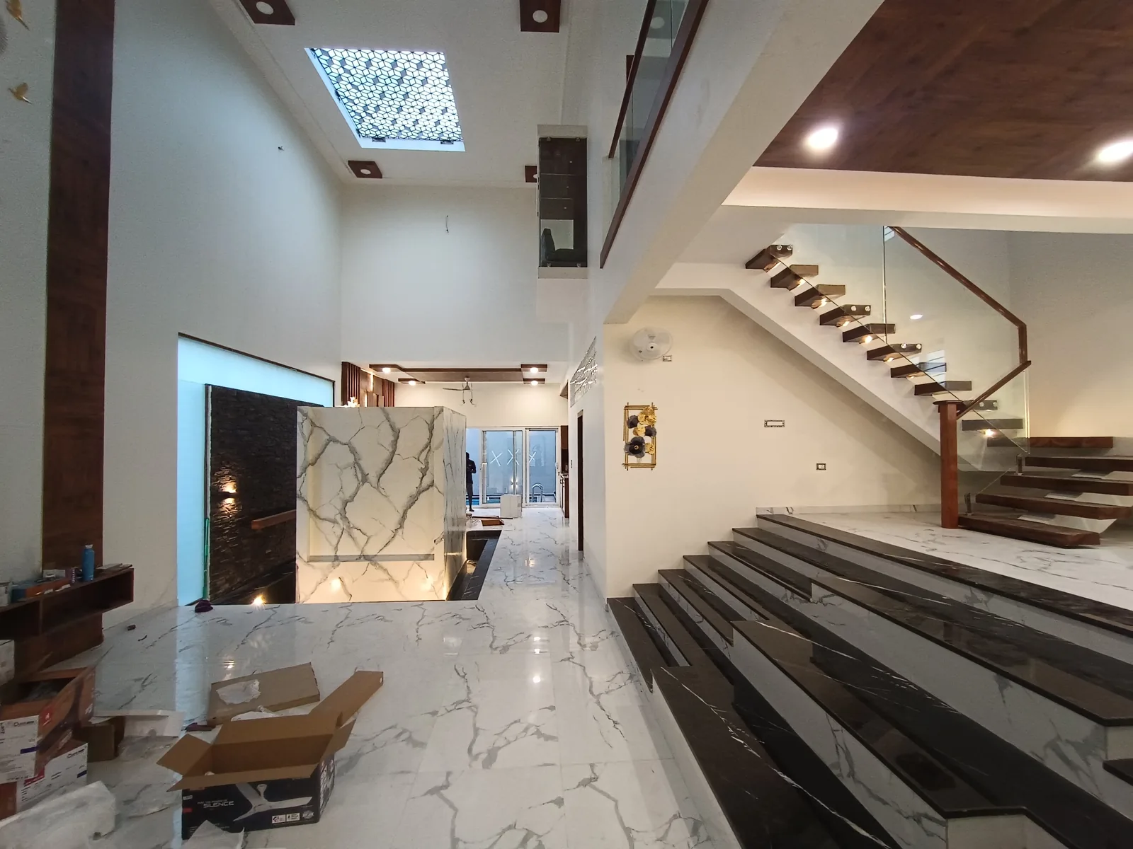 SA Residence — double-height living room with floating staircase, Guduvanchery, Chennai